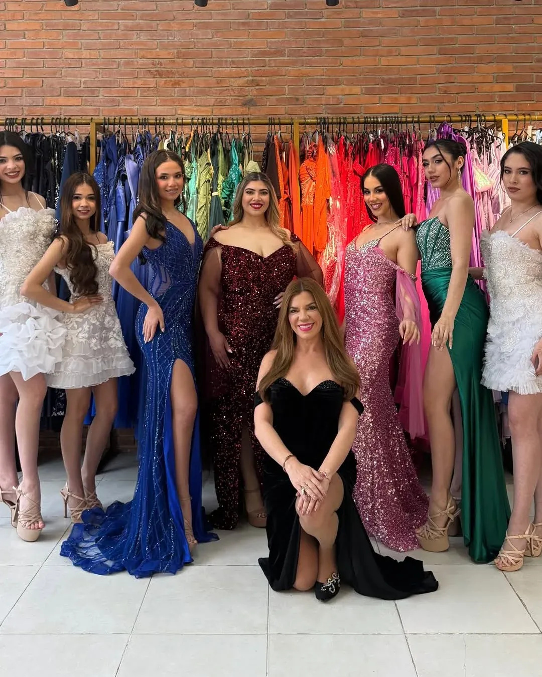 Maru Candia con modelos de Efecto Cenicienta frente a los percheros de vestidos